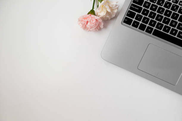 istock Grey laptop with flowers in a white background. Copyspace. Banner. Flat lay. Aerial view 1447004264