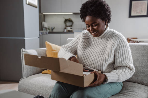 istock Young African-American woman opening package 1447007400