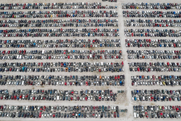 Aerial view of rows of wrecked cars at the junkyard.