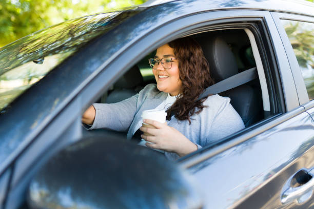 istock Excited fat woman driving with a coffee 1447008001