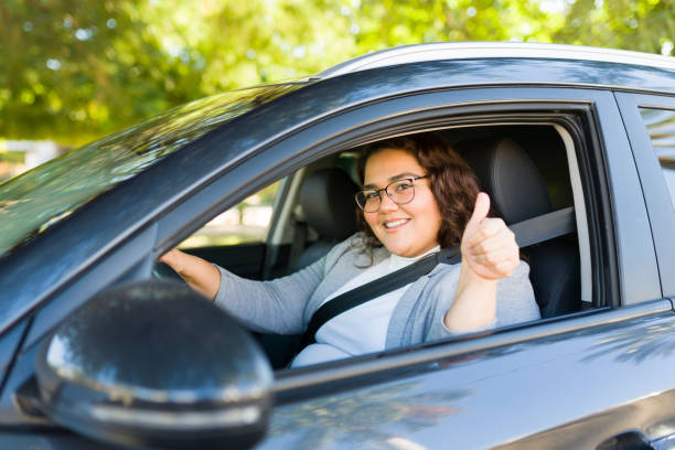 istock Cheerful fat woman making a thumbs up driving 1447008596