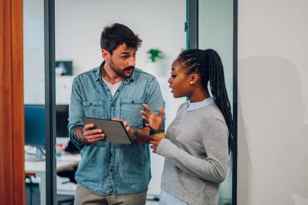 istock Two multiracial business colleagues working together on a digital tablet 1447008605