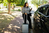 Overweight woman waiting for rideshare service car