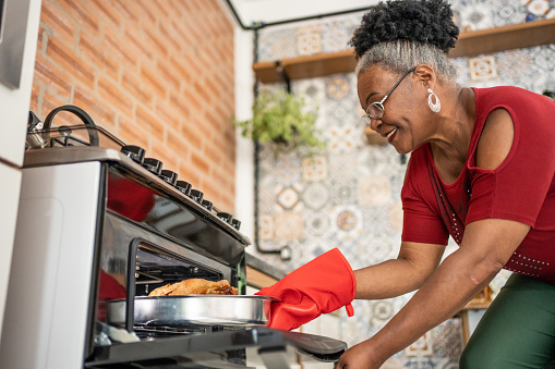 Mature woman taking Christmas turkey out of the oven