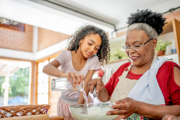 grandma and granddaughters making christmas cookies - grandmother cooking baking family imagens e fotografias de stock