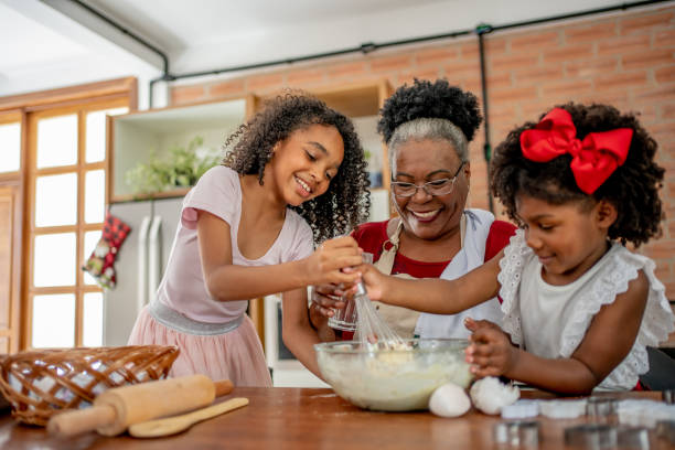 grandma and granddaughters making christmas cookies - grandmother cooking baking family imagens e fotografias de stock