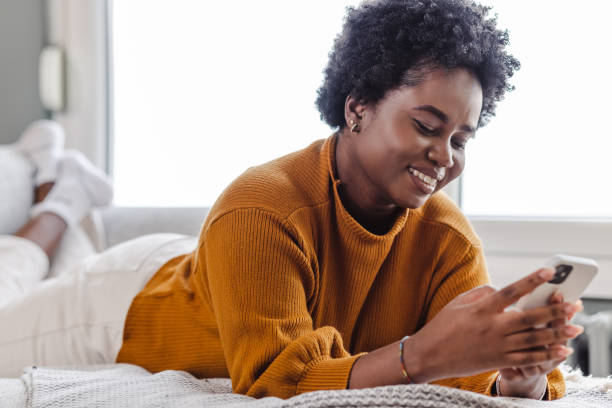 istock A young African woman using a smart phone at home and relaxing 1447011678