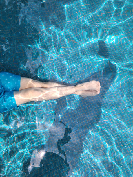 istock Human legs in blue pool water 1447013559