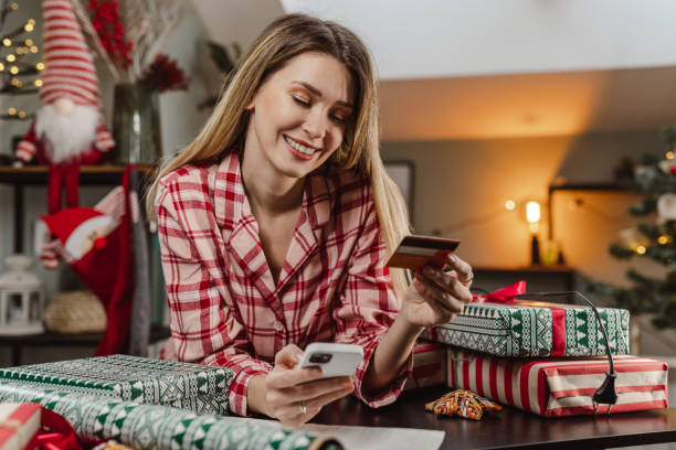 istock Lovely woman using smart phone for e-commerce during Christmas time 1447017490