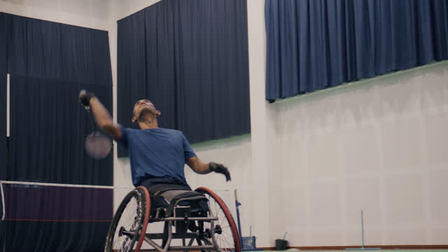 Asian male sits in a competitive wheelchair  practice before match.