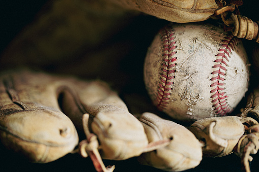 An old, well used baseball and glove.