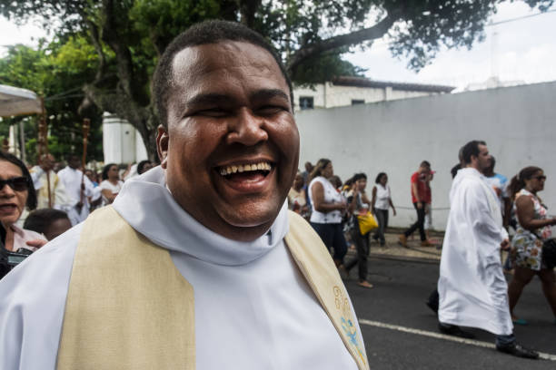 a priest smiles at the camera during the corpus christ procession - confessional nun catholic imagens e fotografias de stock