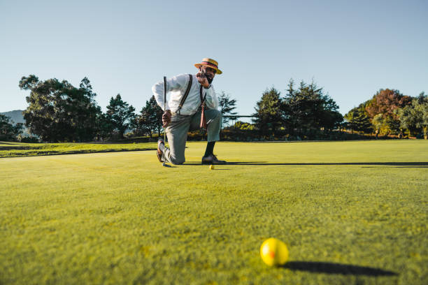 Black man kneeling and playing golf