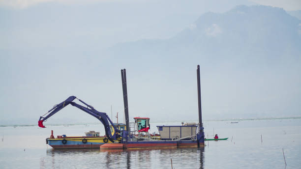 istock dredger equipped with excavator on the lake 1447023007