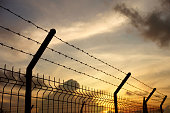 Barbed wire fence against twilight sky Feeling lonely and wanting freedom.