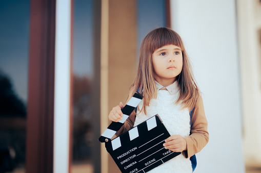 Little wannabe female director holding a film slate