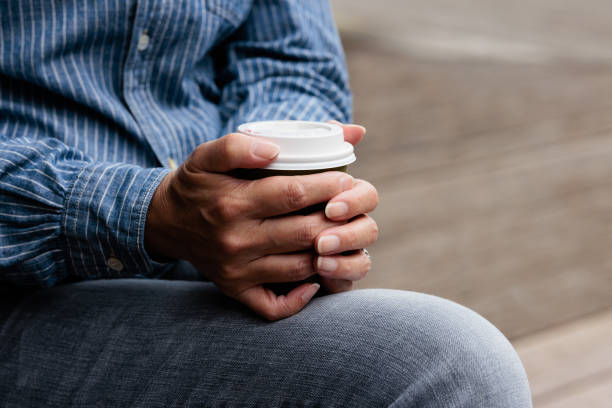 Close-up of a woman holding a coffee cup.
