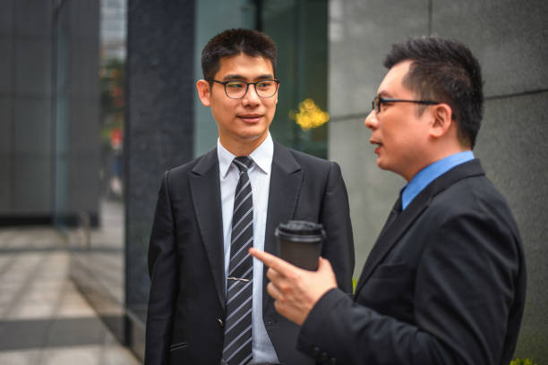 istock Asian Male CEO Talking Outdoors With A Young Intern 1447036100