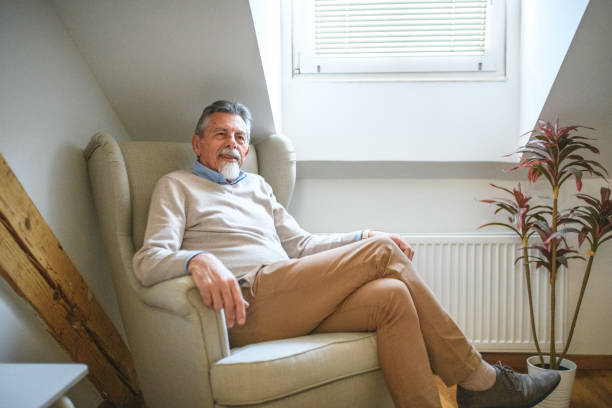 istock Serene and Relaxed White Senior Man Smiling and Looking at Camera While Seated 1447036145