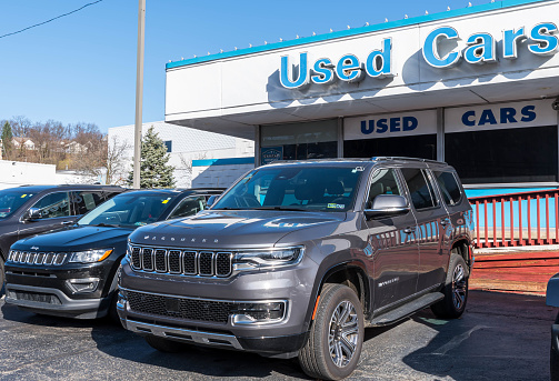 Ross Township, Pennsylvania, USA December 4, 2022 Two used Jeeps, a Cherokee and a Wagoneer for sale at a dealership on a sunny fall day