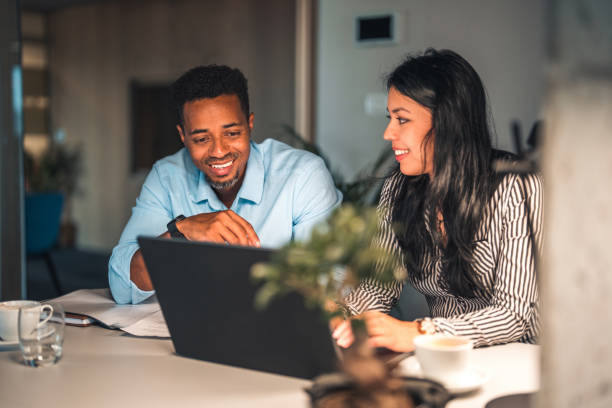 istock Mid Adult Cheerful Coworkers Brainstorming while Using Laptop 1447036260