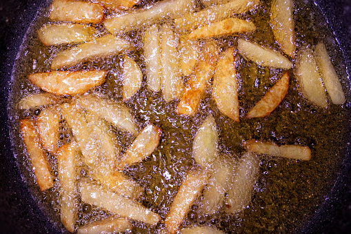French fries french fries in boiling oil. Fried potatoes. Fat and tasty food. Fast food