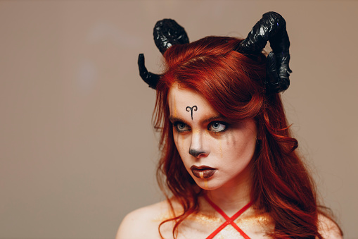 Beautiful young woman with makeup zodiac signs of Capricorn or Aries or Taurus. Girl with horns on head.