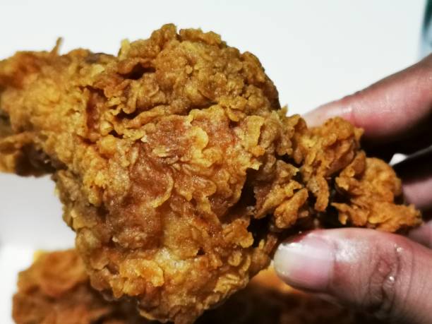 istock A hand squeezing crispy fried chicken with juicy and tender meat 1447041678