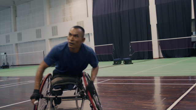 Asian male disability in an blue sportswear sits in a competitive wheelchair preparation before big match.