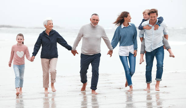 istock Beach, walking and big family on exercise while on vacation in Australia during summer in water. Happy Grandparents, parents and children on outdoor health walk while on adventure, journey or holiday 1447051979