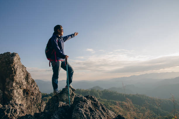 istock Active climbers enjoy the view.female backpacker with backpack and crutches enjoy the sunshine on the mountain, copy space. 1447053547
