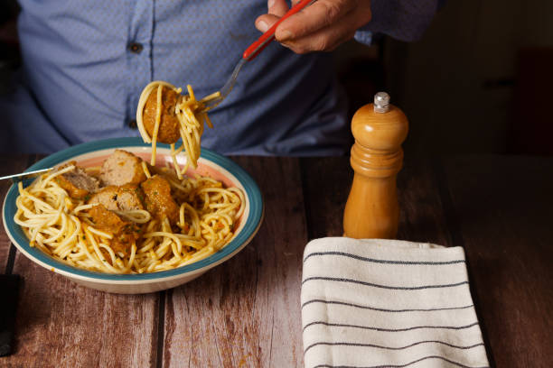 istock man eating meatballs with spaghetti 1447056276