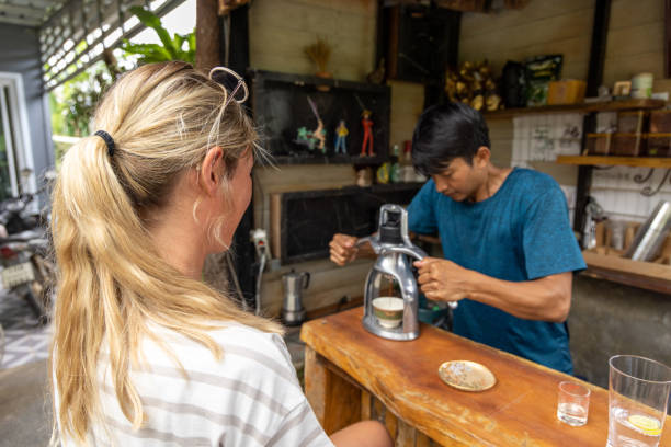 młoda kobieta pijąca espresso w lokalnej kawiarni w azji, doświadczalna podróż z różnorodnością - caffeine caucasian satisfaction small business zdjęcia i obrazy z banku zdjęć