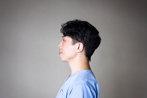 Japanese model. Smiling
He wears a medical scrubs.
Side view.