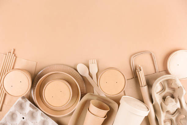 istock Paper utensils, cups, plates, drinking straws, egg boxes, bamboo cutlery set and food containers over light brown background with copy space. Food delivery service, sustainable paper packaging 1447062269