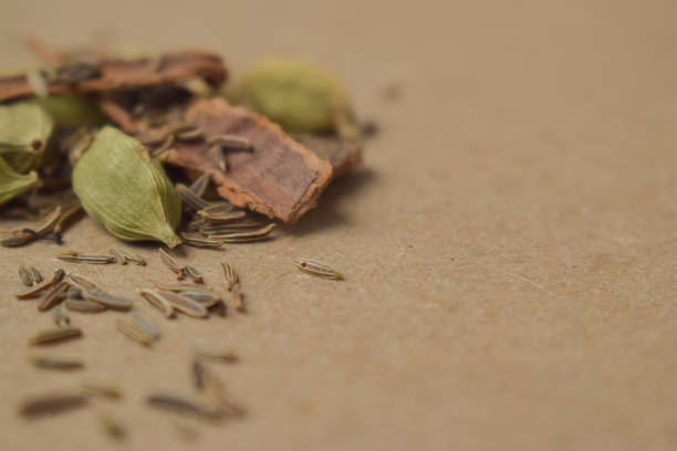 mezcla de especias indias garam masala, semillas de cardamomo, canela y semillas de comino aisladas sobre fondo amarillo - spice exoticism cinnamon anise fotografías e imágenes de stock