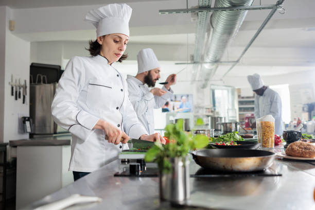 istock Sous chef preparing fresh vegetable garnish for gourmet dish served at dinner service in restaurant. 1447065379