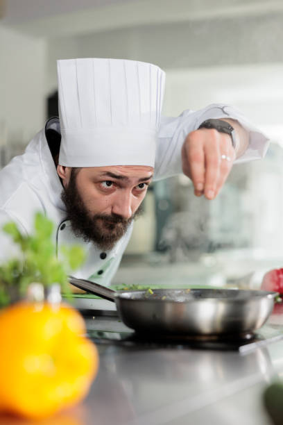 istock Master cook putting parmesan cheese in food while preparing meal for dinner service at restaurant. 1447065971