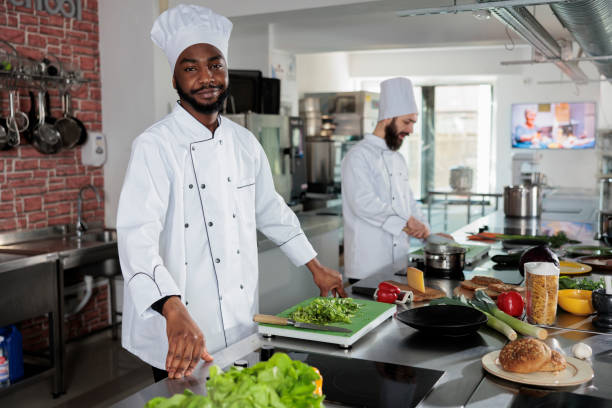 istock Skilled head chef wearing cooking uniform while preparing ingredients for dish in restaurant professional kitchen. 1447066281