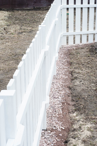 Perspective photo of a clean painted wooden fence in the street
