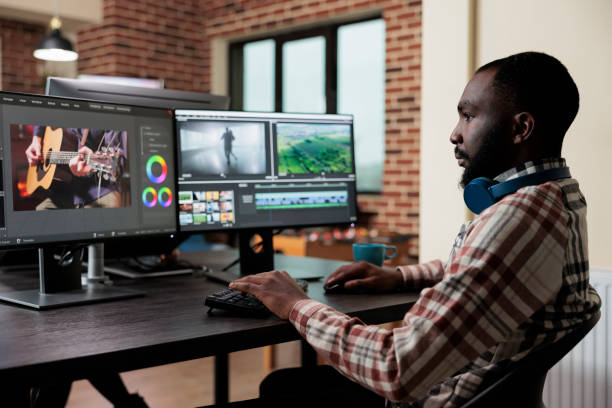 istock Digital footage professional editor at multi monitor workstation improving visual quality of content. 1447070435
