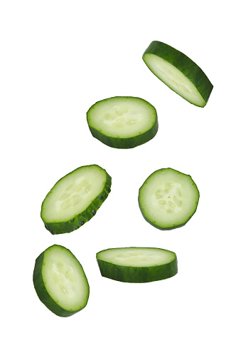 Soaring cucumber slices isolated on white background.