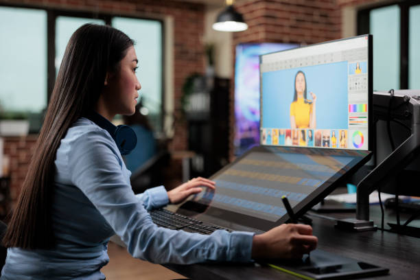 istock Creative agency asian employee retouching digital photos while using touchscreen display and stylus pen. 1447070606