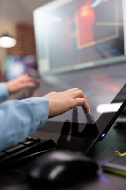 istock Close up of creative game creator hands on multiple modern displays while optimising videogame project. 1447070735