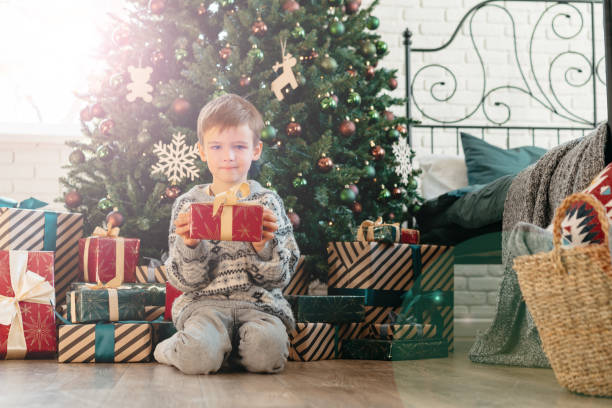 istock Cute little boy holding a gift box for Christmas 1447071454