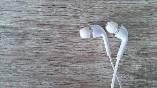 White earphone on wooden background