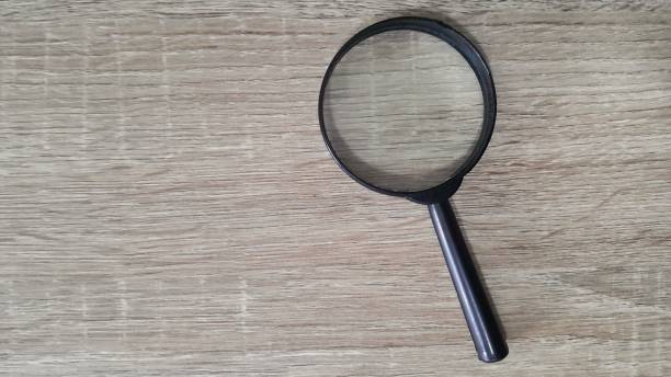 istock Magnifying glass on wooden background 1447072398