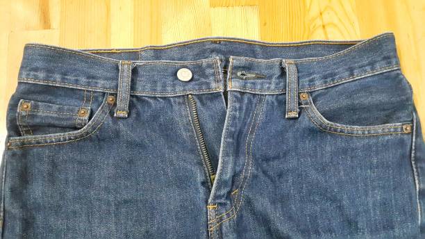 istock Blue jeans on wood background 1447072400