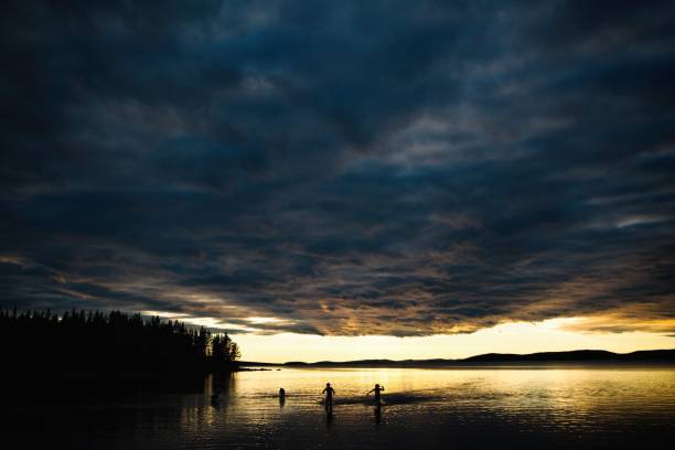 istock People's silhouettes on a boat during sunset 1447074437