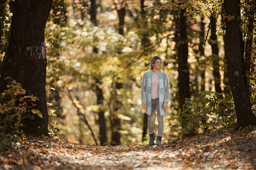 Carefree woman day dreaming during autumn day in nature. Copy space.